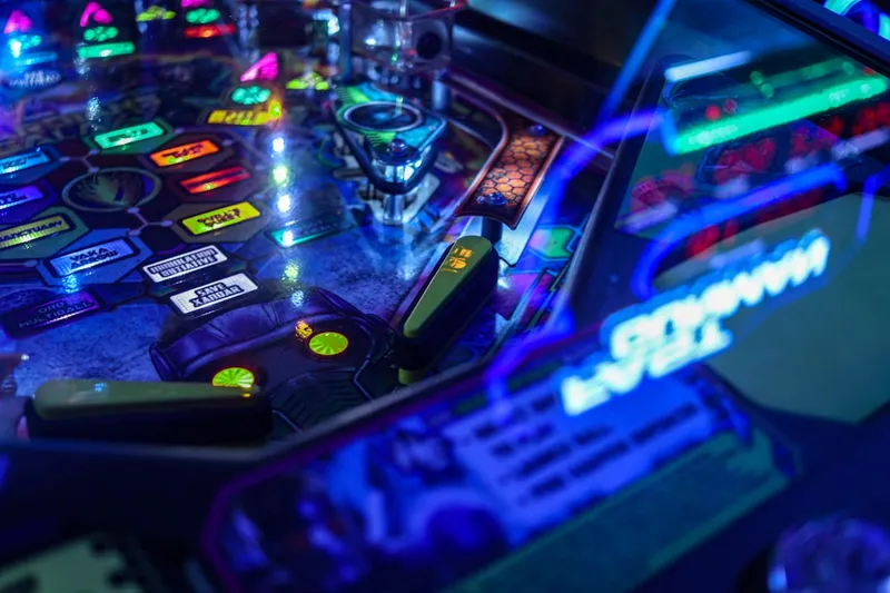 a close up of a pinball machine with neon lights
